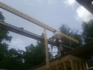 Carpenter setting a ridge beam over a new addition frame — Ice Dam Removal by Roofing Brothers in Woodstock Valley