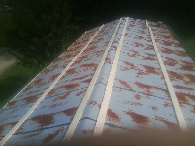 Rusted metal roof panels with new wood purlins before replacement — Storm Damage Roof Repair in Woodstock Valley by Roofing Brothers