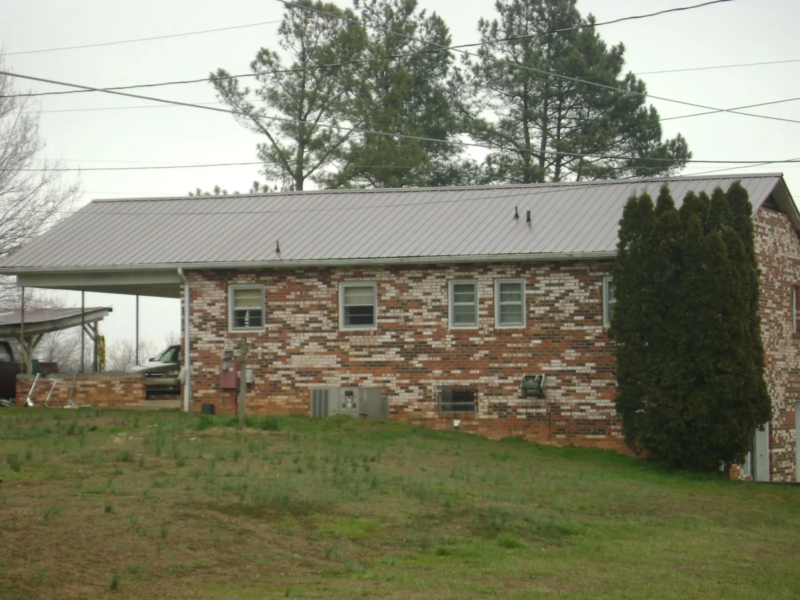 Gray metal roof on a brick split level home with a carport in Woodstock Valley