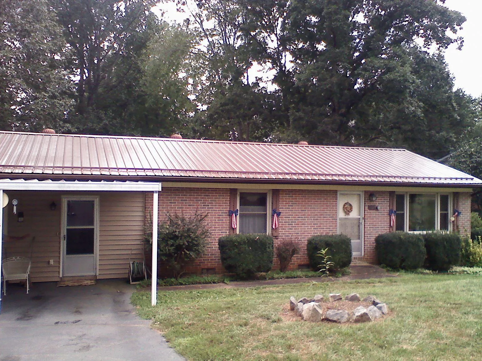Bronze metal roof and carport on a brick ranch home — Roof Repair work by our crew in Woodstock Valley
